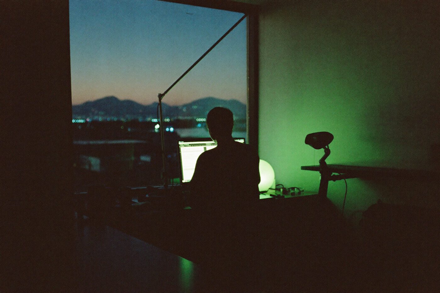 Working by a window over the city at blue hour