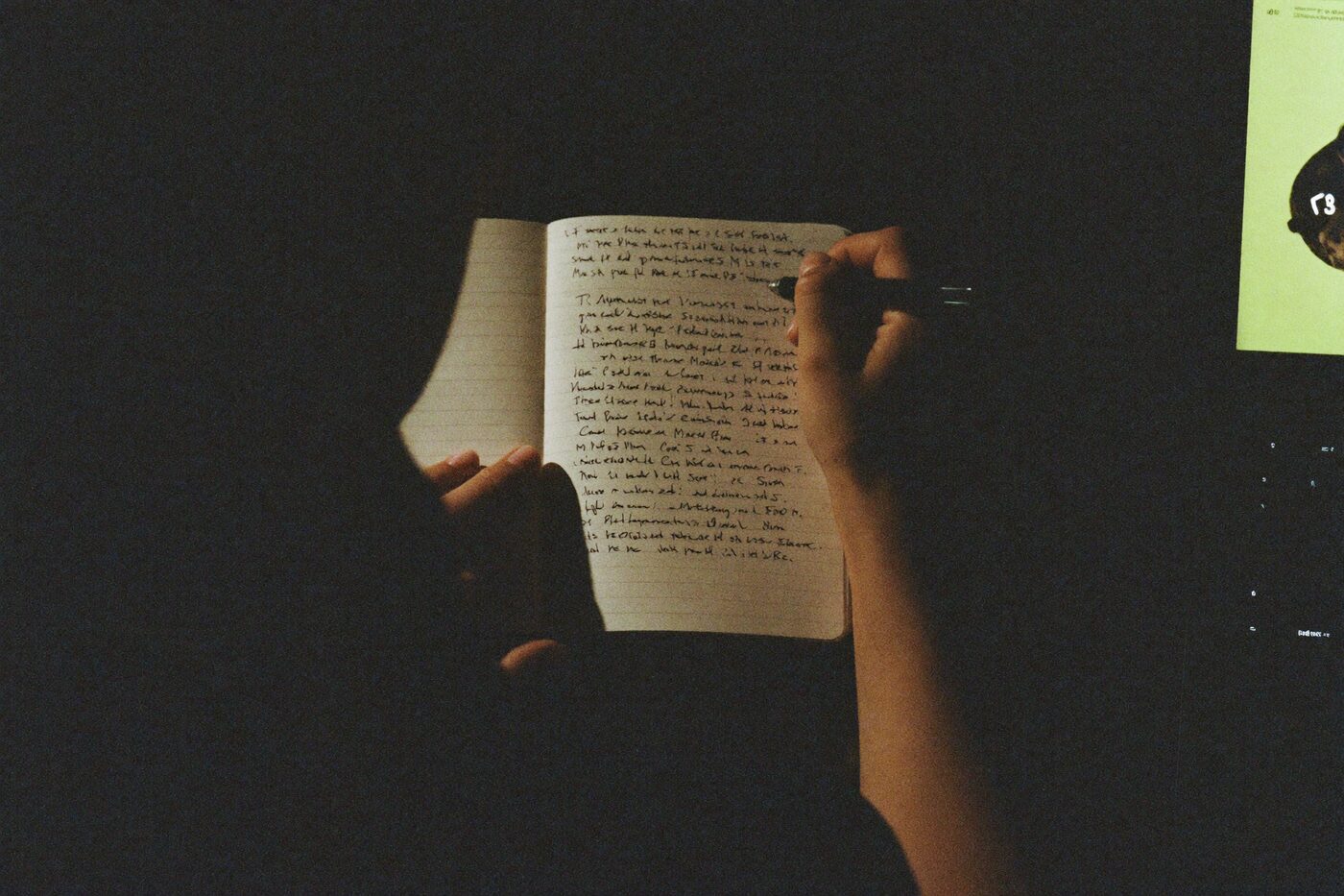 Writing notes by the glow of a screen at night
